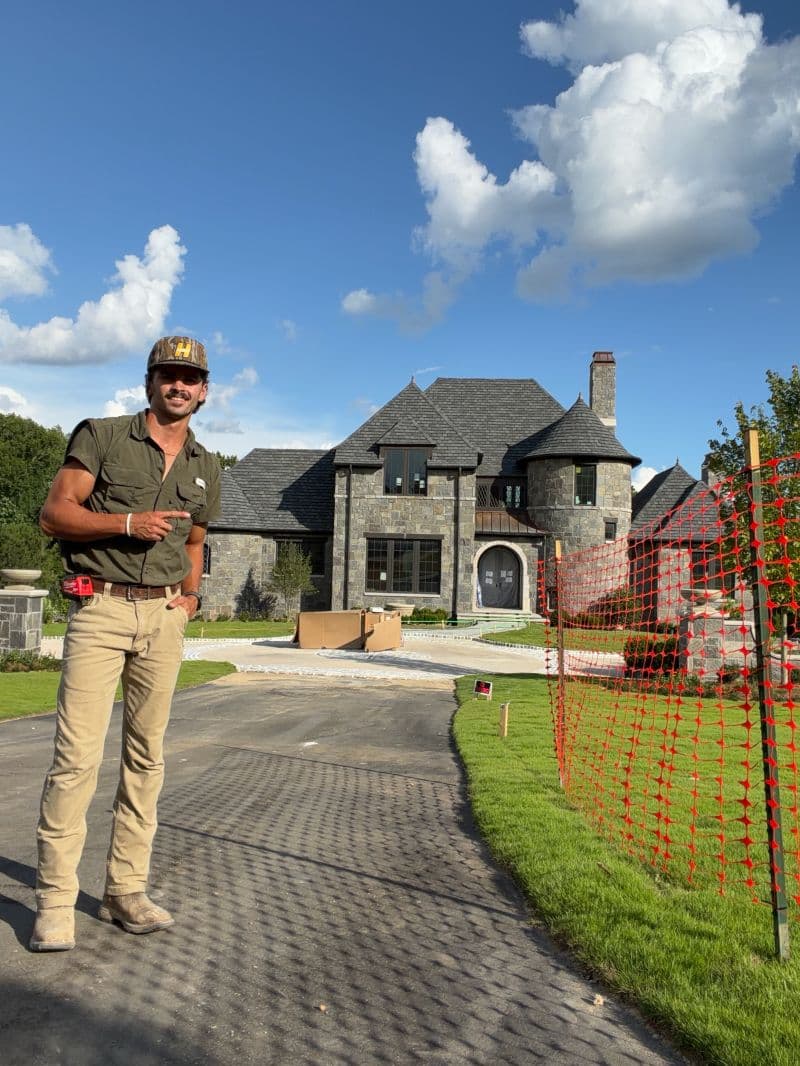 Seth standing beside a custom home during construction